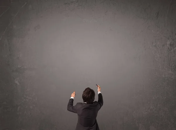 Businessman standing in front of an empty wall — Stock Photo, Image