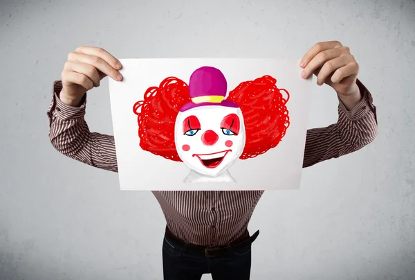 Geschäftsmann hält einen Karton mit einem Clown davor — Stockfoto