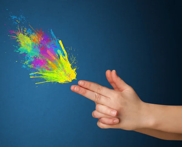 Colorful splashes are coming out of gun shaped hands — Stock Photo, Image