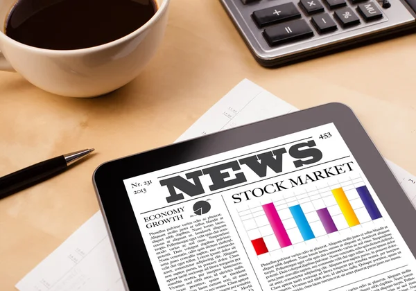 Tablet pc shows news on screen with a cup of coffee on a desk — Stock Photo, Image