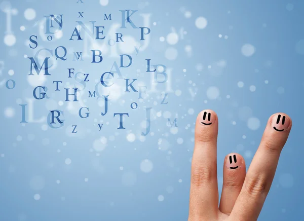 Happy smiley fingers looking at mixture of bokeh letters — Stock Photo, Image