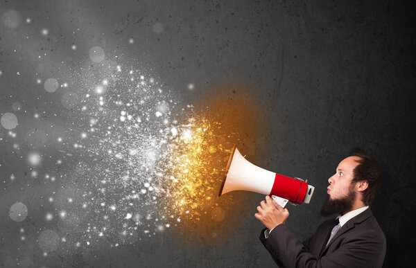 Парень, кричащий в мегафон и пылающие частицы энергии взрываются