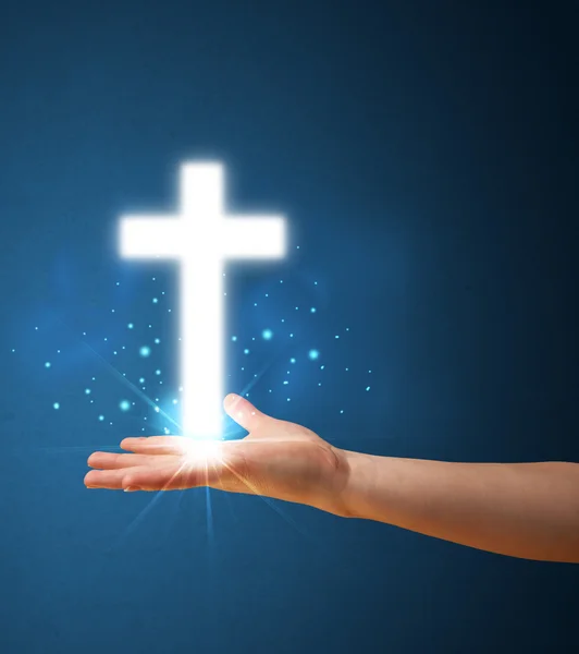 Светящийся крест в руке женщины — стоковое фото