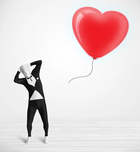 Słodkie facet w morpsuit ciało garnitur patrząc na a balon kształt serce — Zdjęcie stockowe