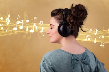 Kulaklıklı genç bir kadın müzik dinliyor.