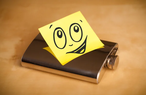 Post-it note with smiley face sticked on hip flask — Stock Photo, Image