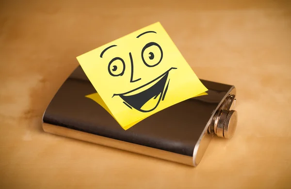 Post-it note with smiley face sticked on a hip flask — Stock Photo, Image