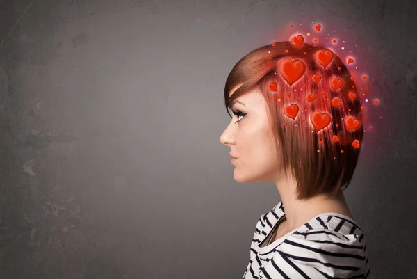 Ung människa tänker på kärlek med röda hjärtan — Stockfoto