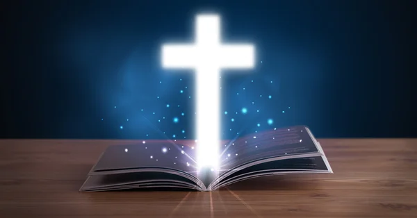 Open holy bible with glowing cross in the middle — Stock Photo, Image