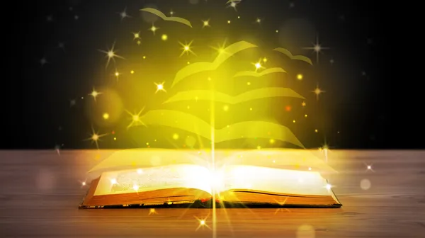 Open book with golden glow flying paper pages — Stock Photo, Image