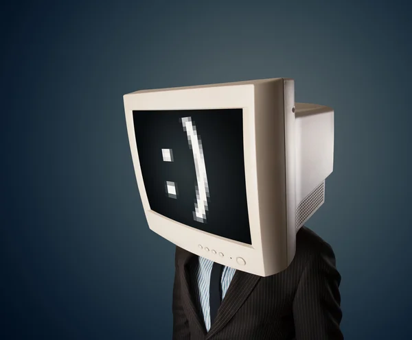 Funny young businessman with a monitor on his head and smiley on — Stock Photo, Image