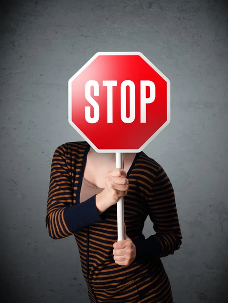 Young woman holding a stop sign — Stock Photo, Image