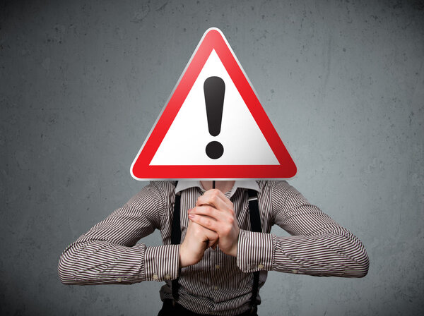 Businessman holding an exclamation road sign