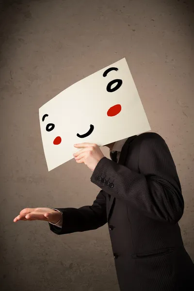 Businessman holding a cardboard with a smiley face on it — Stock Photo, Image