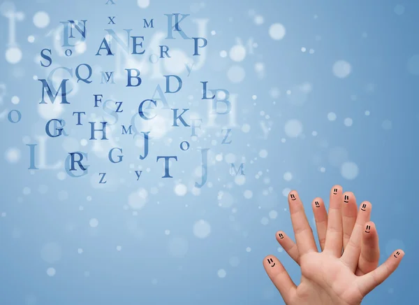 Happy smiley fingers looking at mixture of bokeh letters — Stock Photo, Image