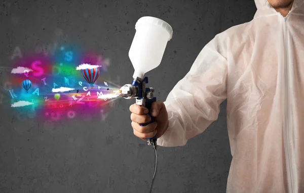 Trabajador con aerógrafo y nubes abstractas coloridas y globos — Foto de Stock