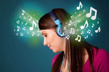 Kulaklıklı genç bir kadın müzik dinliyor.