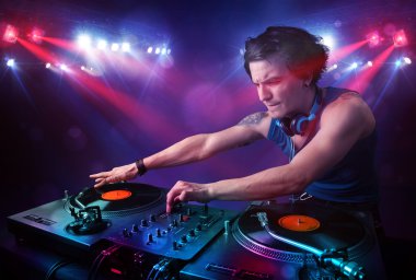 Genç dj kayıtları bir kalabalığın önünde sahnede karıştırma
