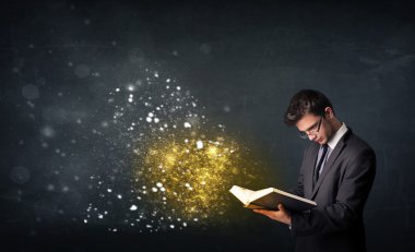 Genç adam sihirli bir kitap okuyor.