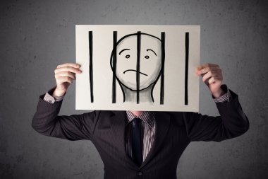 esir parmaklıklar arkasında bir kağıt üzerinde tutan işadamı