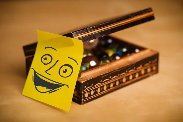 Post-it σημείωση με χαμογελαστό πρόσωπο sticked σε ένα κιβώτιο κοσμήματος — Φωτογραφία Αρχείου