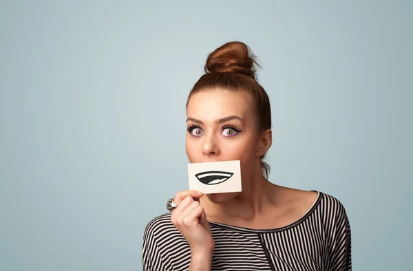 Pretty young girl holding white card with smile drawing — Stock Photo, Image