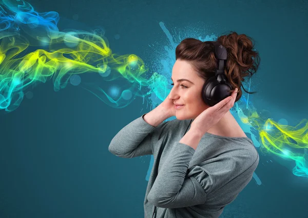 Ung kvinna lyssnar på musik med hörlurar — Stockfoto