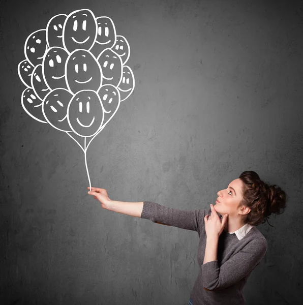 Woman holding a bunch of smiling balloons — Stock Photo, Image