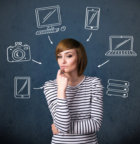 Jeune femme pensant avec des gadgets dessinés autour de sa tête — Photo