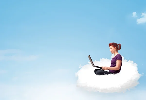 Young woman with laptop sitting on cloud with copy space — Stock Photo, Image