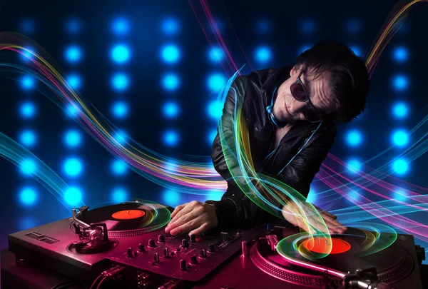 Young Dj mixing records with colorful lights — Stock Photo, Image