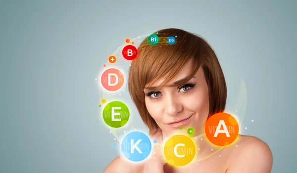 Menina bonita com ícones de vitaminas coloridas e símbolos — Fotografia de Stock