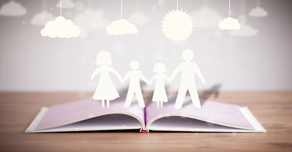 Figur kardus keluarga pada buku yang dibuka — Stok Foto