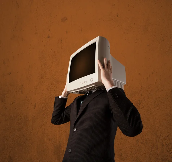 Homem de negócios com um monitor na cabeça e espaço vazio castanho — Fotografia de Stock