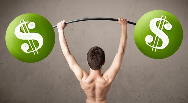 Skinny guy lifting green dollar sign weights — Stock Photo, Image