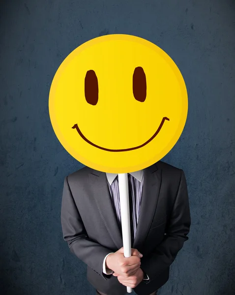 Homme d'affaires tenant un visage souriant émoticône — Photo