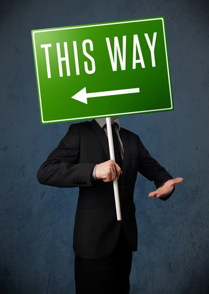 Businessman holding a direction sign — Stock Photo, Image