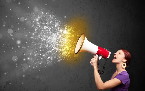 Woman shouting into megaphone and glowing energy particles explo — Stock Photo, Image