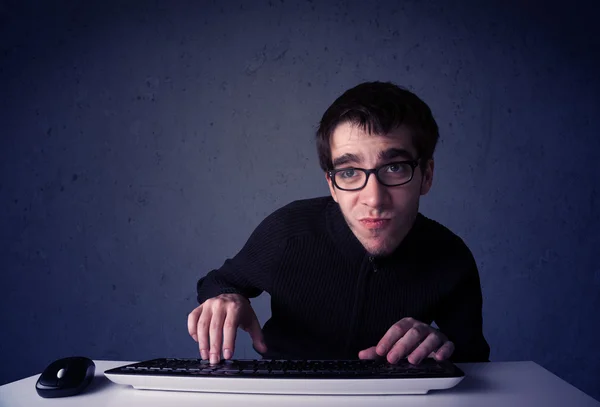 Хакер працює з клавіатурою на синьому фоні. — стокове фото
