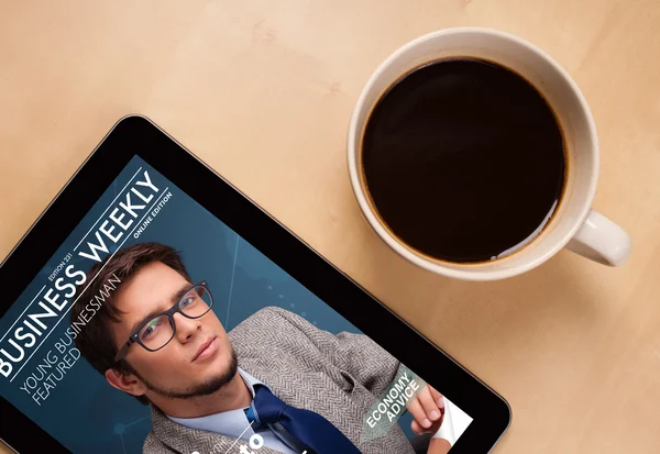 Tablet pc ukazuje časopis na obrazovce s šálkem kávy na d — Stock fotografie