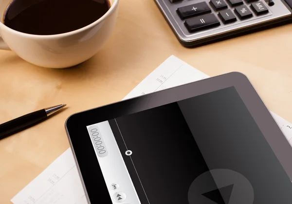 Tablet PC que muestra el reproductor multimedia en la pantalla con una taza de café en — Foto de Stock