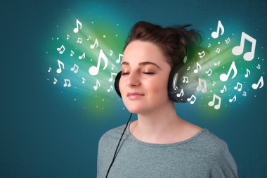 Kulaklıklı genç bir kadın müzik dinliyor.