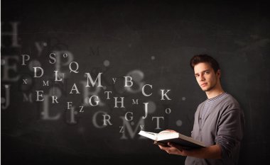 genç adam alfabesi harfleri ile kitap okuma