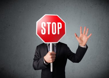 İşadamı elinde dur levhası tutuyor.