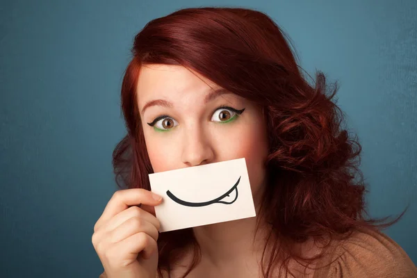 Красива молода дівчина тримає білу листівку з малюнком посмішки — стокове фото