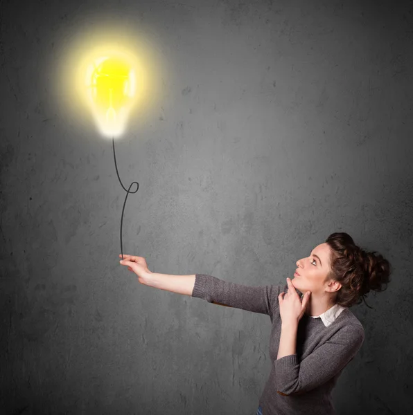 Woman holding a lightbulb balloon — Stock Photo, Image