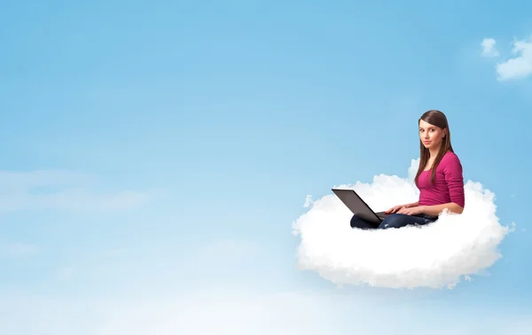 年轻女子坐在云与副本空间上的笔记本电脑 — 图库照片