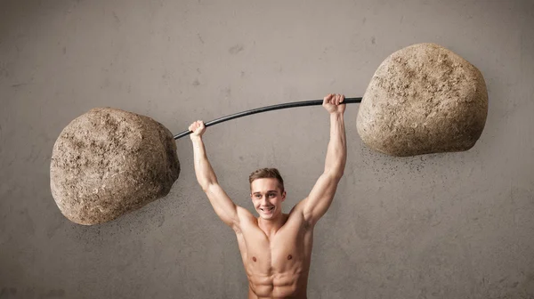 Muscular man lifting large rock stone weights — Stock Photo, Image