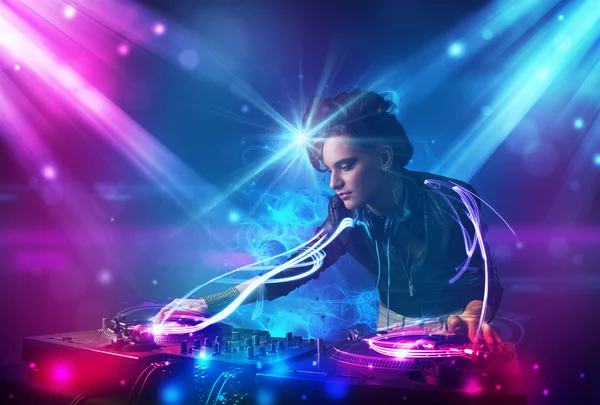 Energetic Dj girl mixing music with powerful light effects — Stock Photo, Image