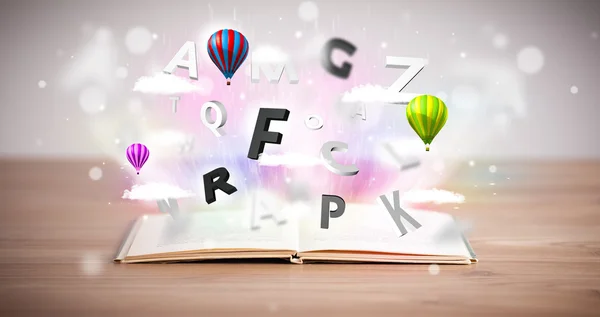Aufgeschlagenes Buch mit fliegenden 3D-Buchstaben auf Betongrund — Stockfoto